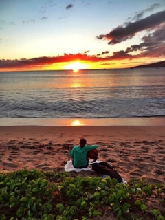 Mailea playing guitar at sunset