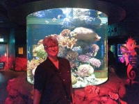 Nan standing by a coral reef exhibit